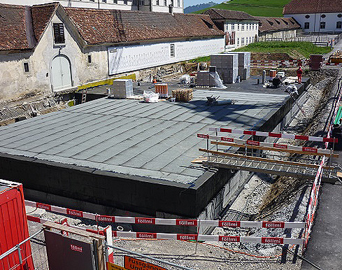 Bild 1: Neubau des unterirdischen Büchermagazins im Kloster Einsiedeln (450 m2). Im Vordergrund schwarz die Isolation der Wände, die jedoch nur bis ca. 50cm unter die Erdoberfläche führt. In tieferen Schichten war gemäss einer dynamischen Simulation des Klimas nur eine dünne Isolation nötig.